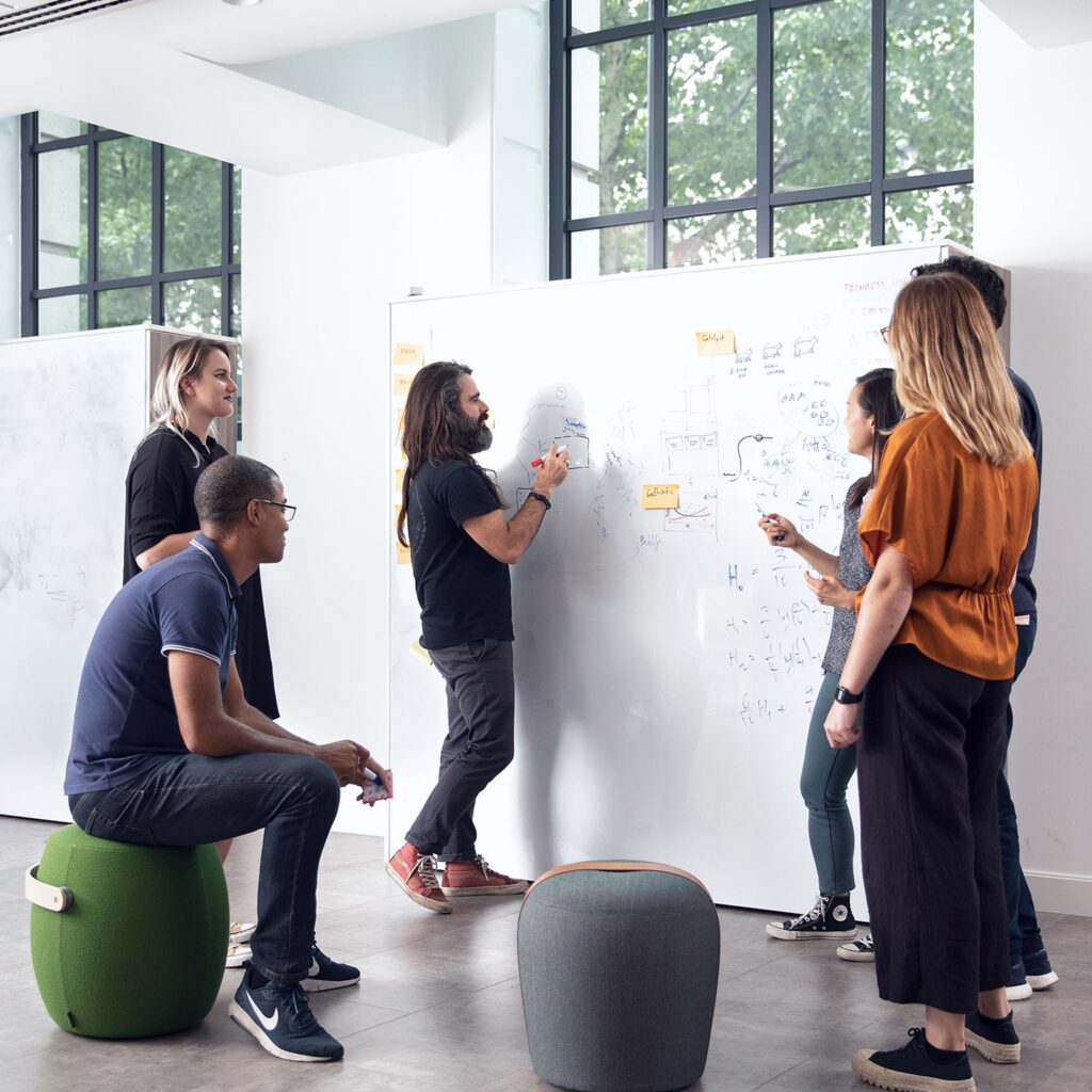 A team working together to solve a problem after a leader invites collaboration instead of pretending to have every answer.
