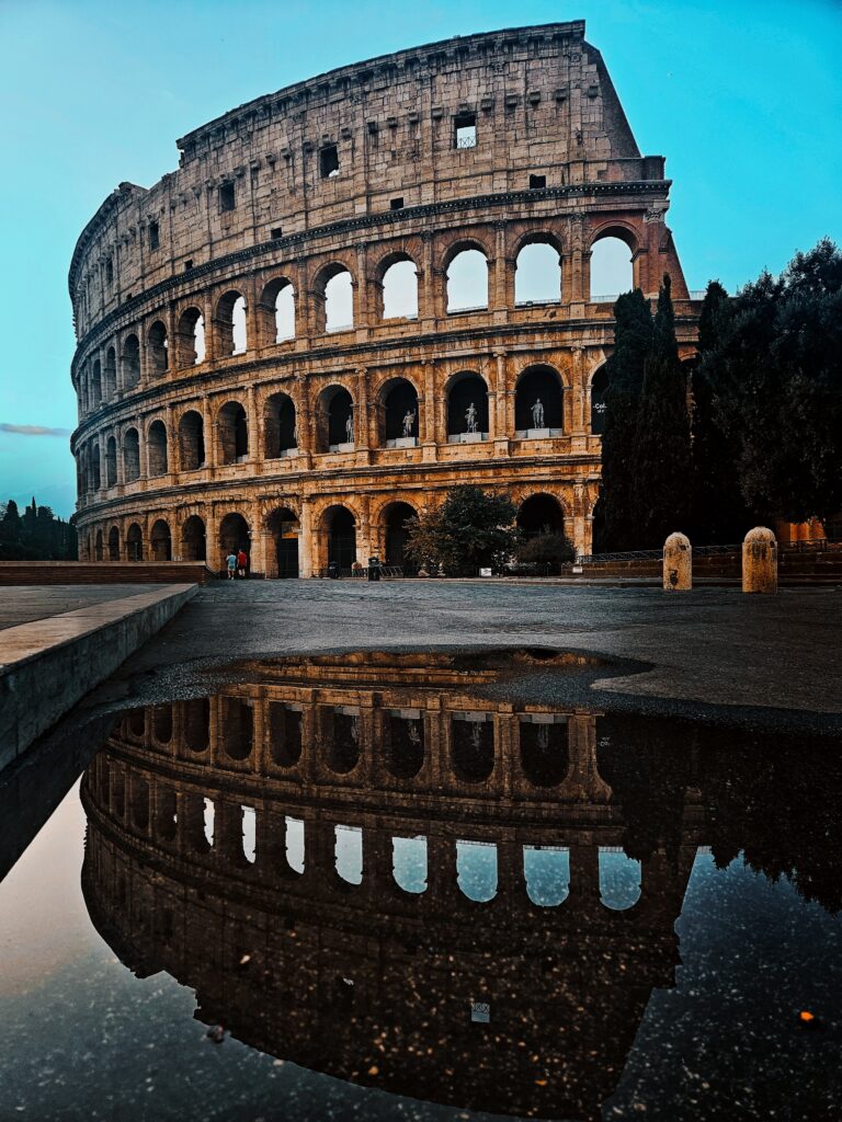 Colosseum in Rome reflected in rainwater during an early morning visit.