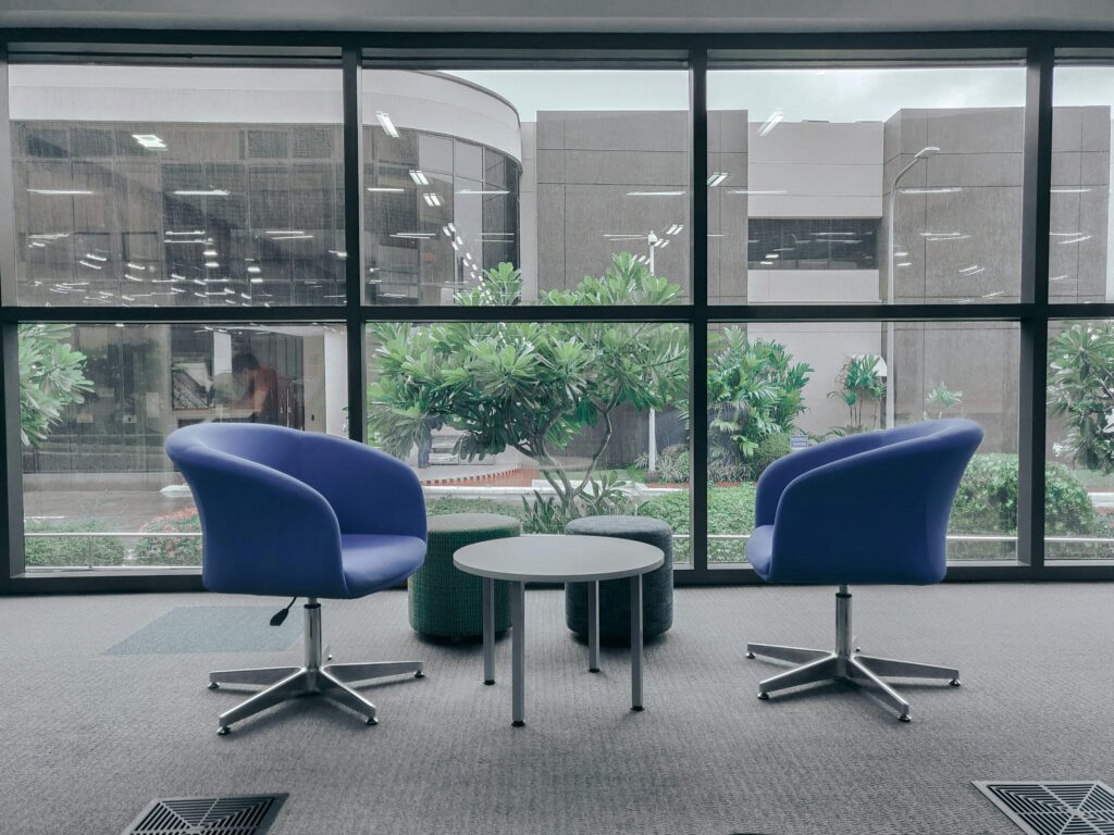 Two chairs facing each other in a quiet meeting room before a difficult conversation.