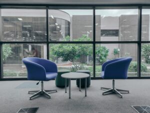 Two chairs facing each other in a quiet meeting room before a difficult conversation.