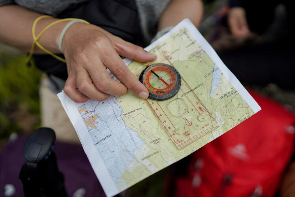 A hiker checking a map while traveling, representing a leader adjusting direction as new information becomes available.