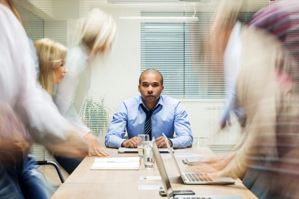 A leader remaining composed during a busy workplace meeting.