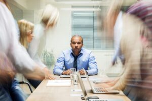 A leader remaining composed during a busy workplace meeting.