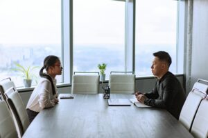Two colleagues discussing a workplace problem across a conference table.