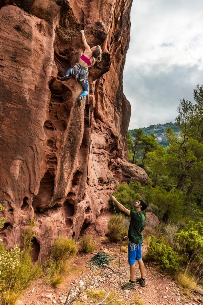Climber supported by a belayer, representing trust, guardrails, and ownership in leadership.