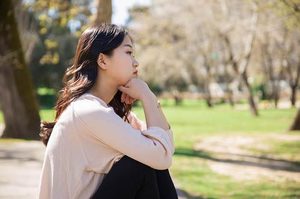 Person sitting quietly alone without distractions, reflecting in a moment of stillness.